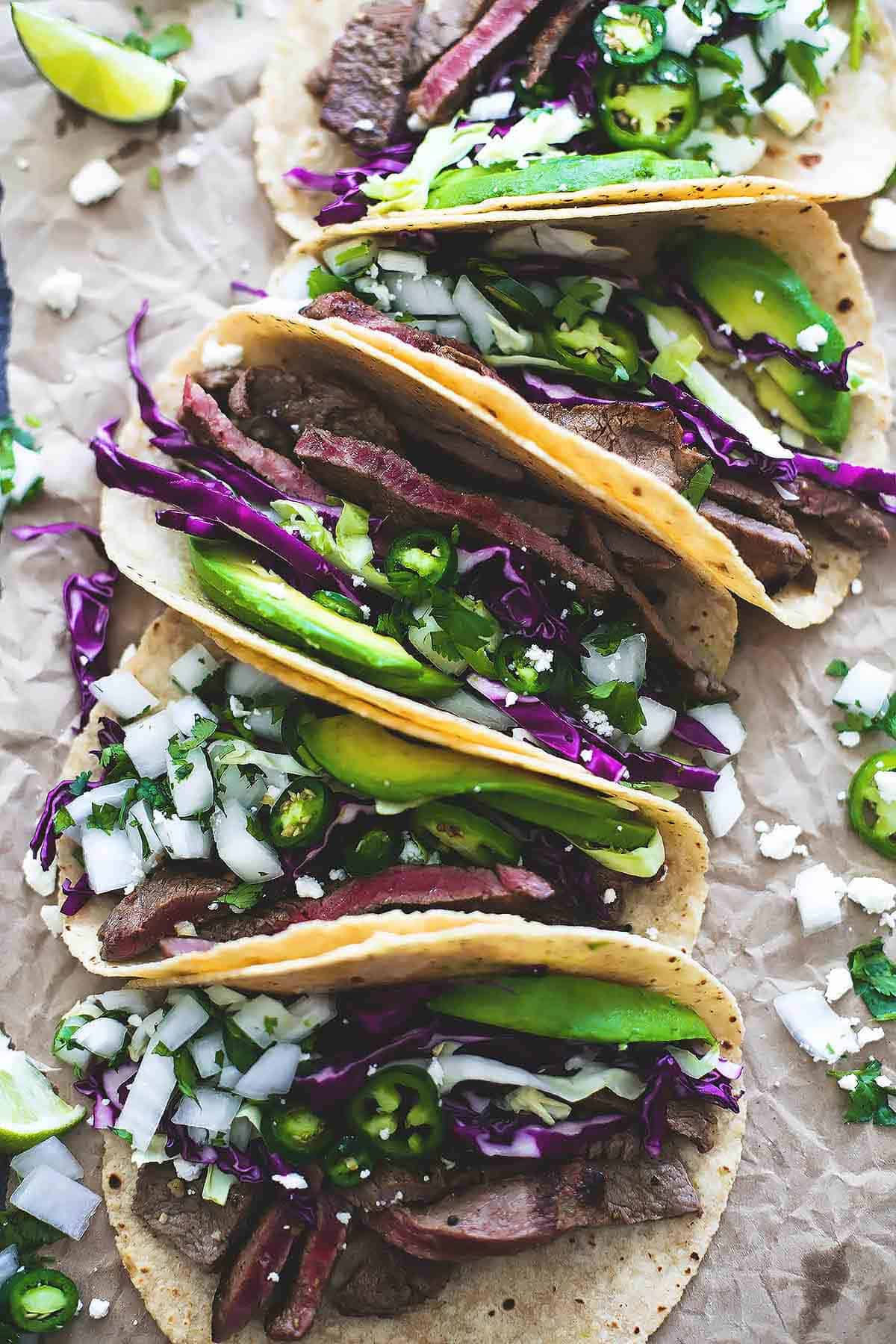 top view of mojo steak tacos lined up vertically.