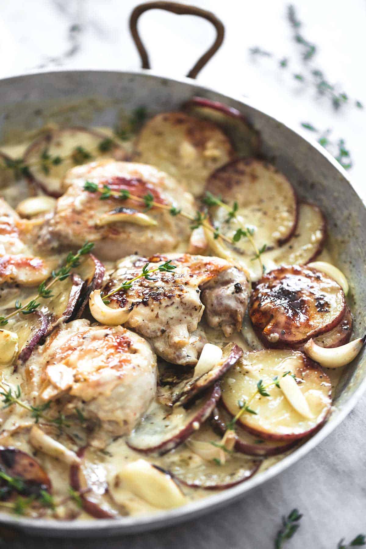 creamy garlic herb chicken & potatoes in a pan.