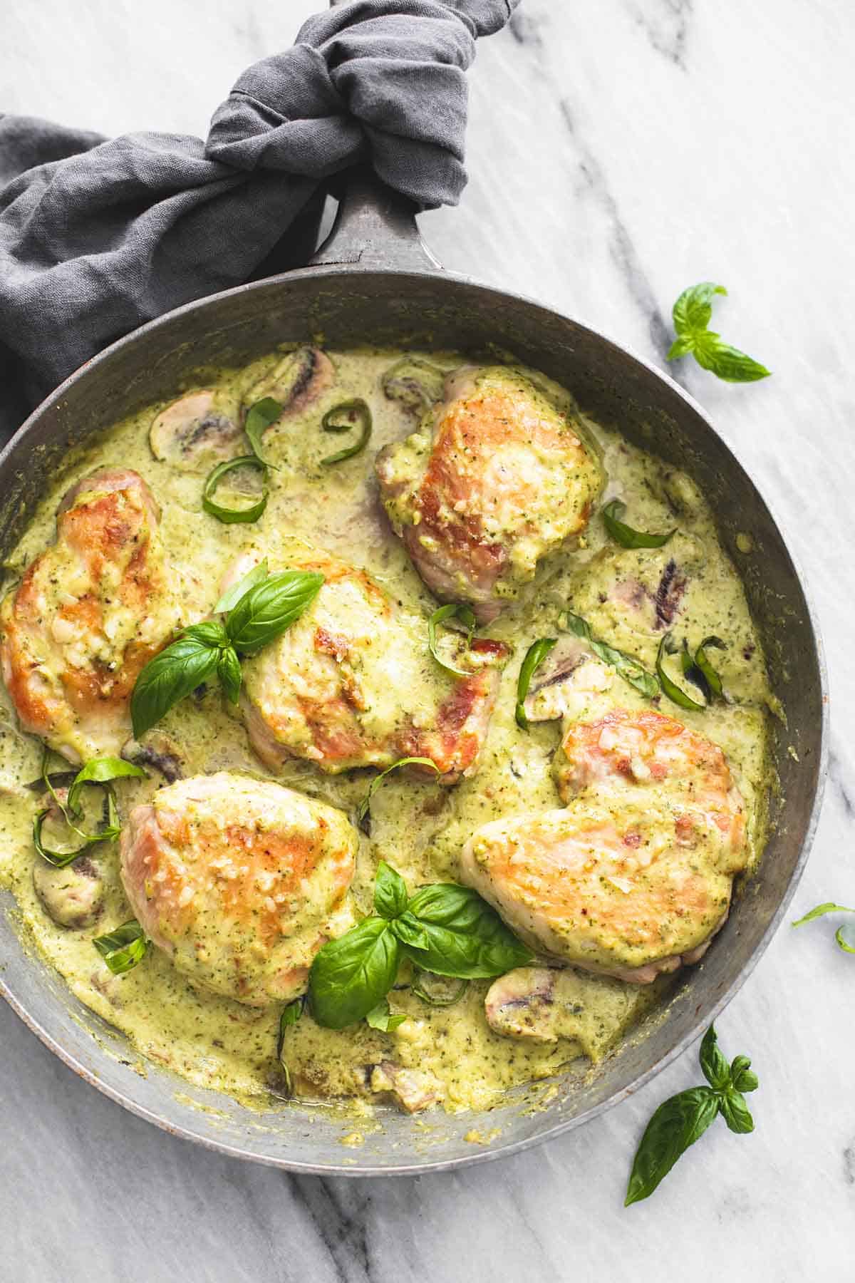 top view of creamy pesto parmesan chicken in a pan.