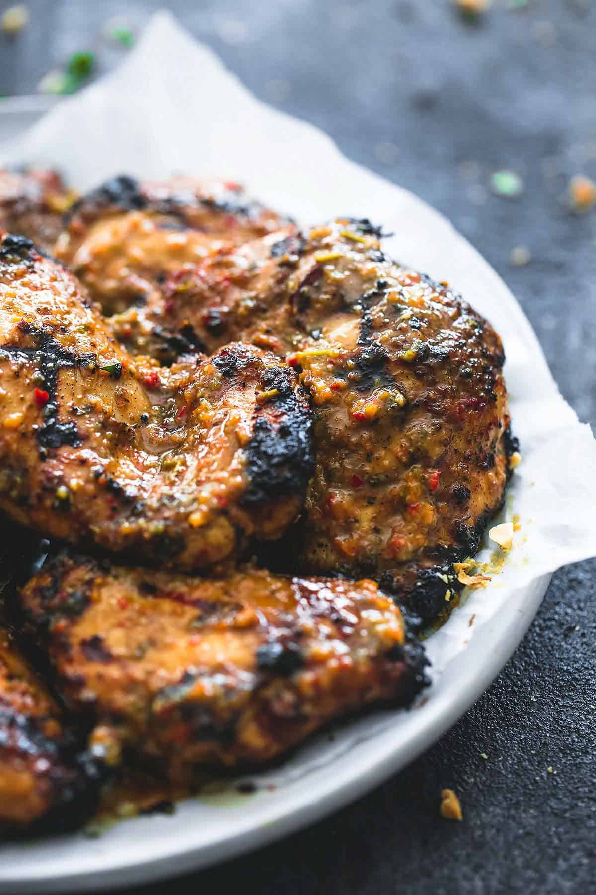 close up of grilled Jamaican jerk chicken on a plate.