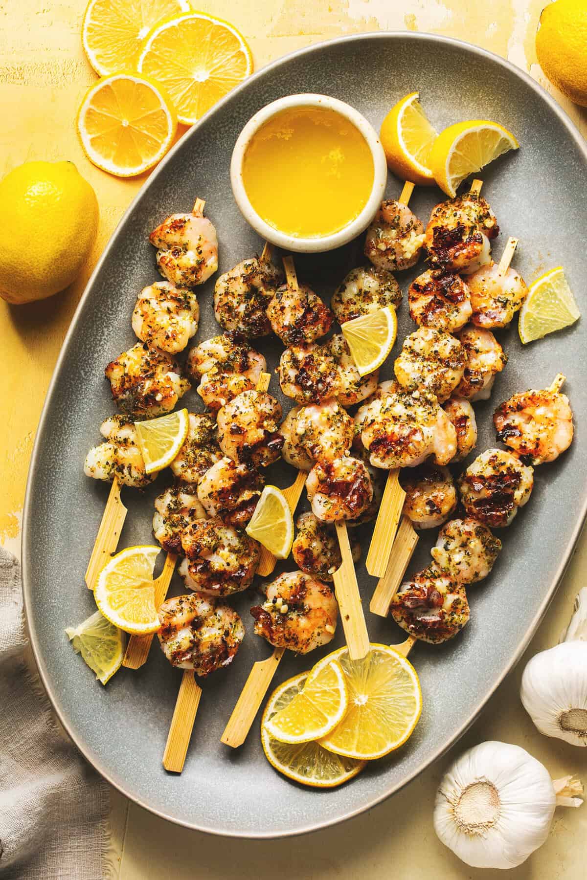 lemon garlic butter shrimp on wooden skewers on serving platter.