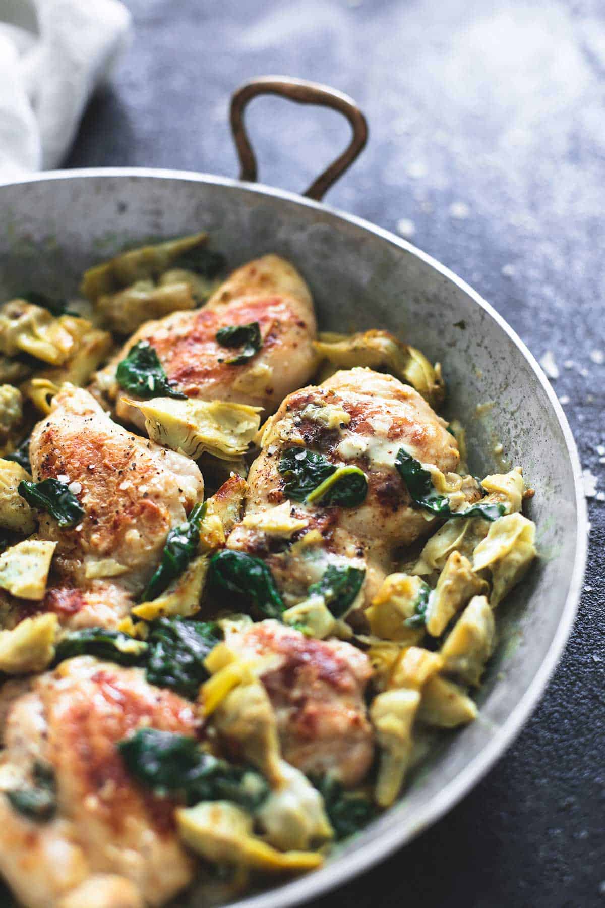 spinach artichoke chicken in a skillet.