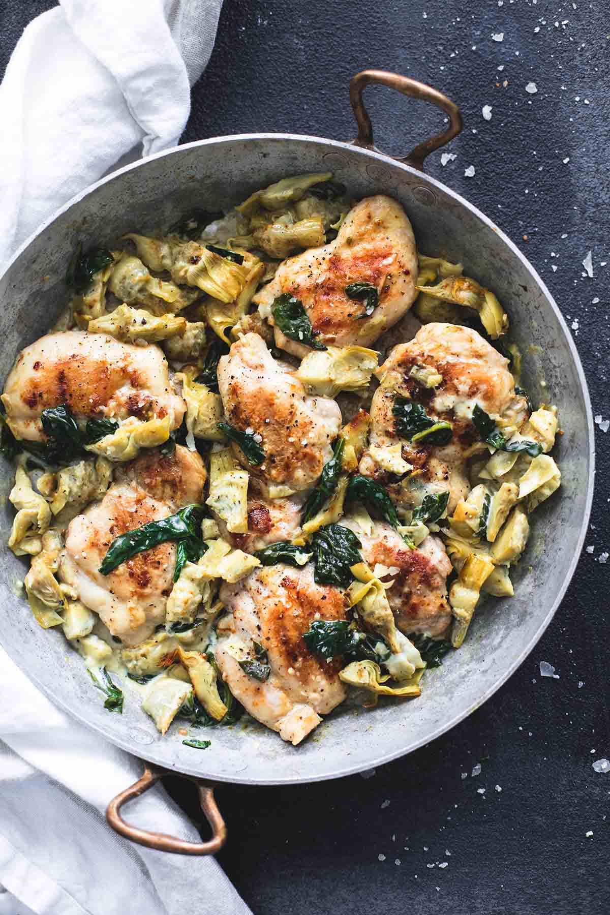 top view of spinach artichoke chicken in a skillet.