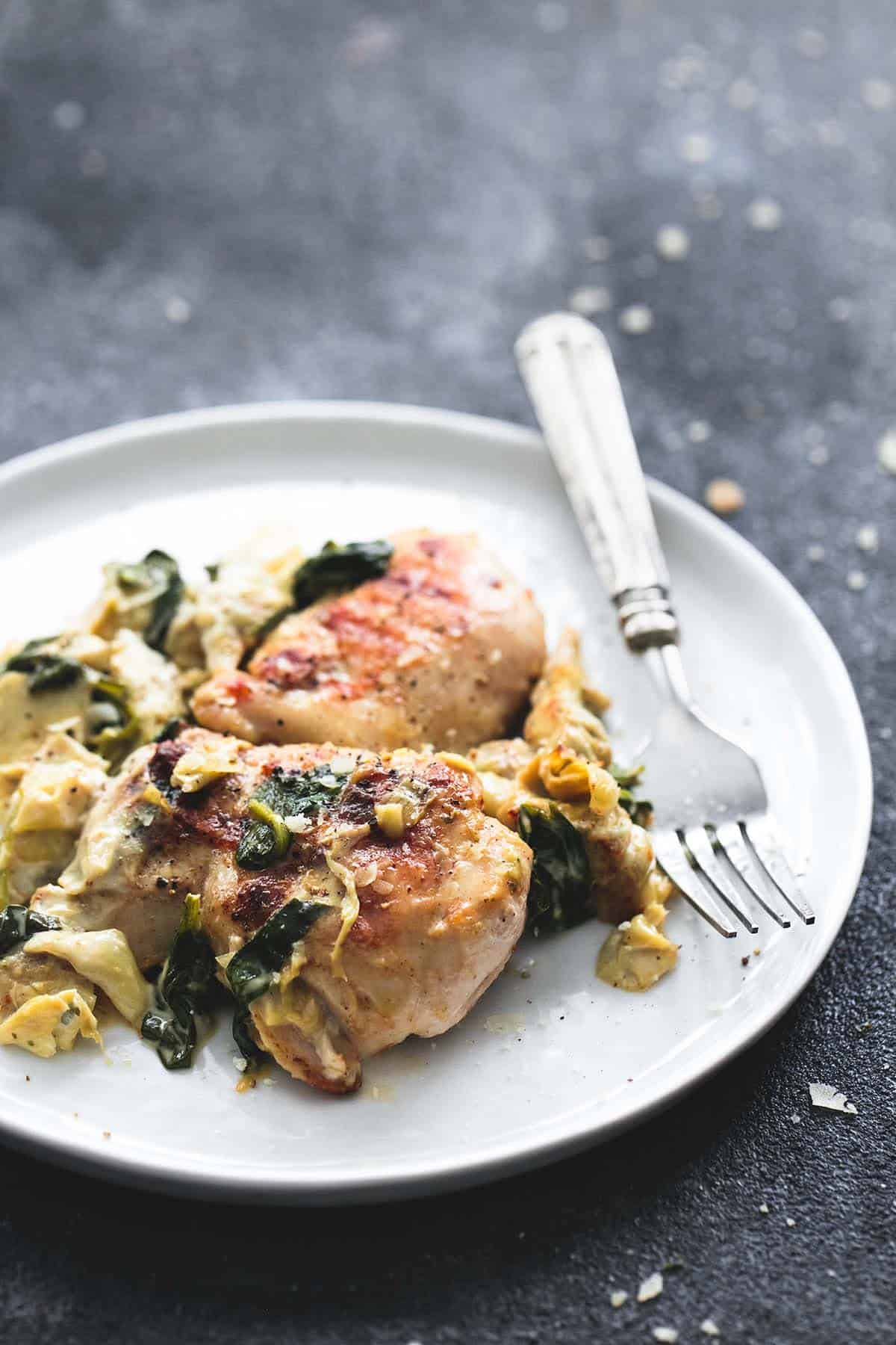 spinach artichoke chicken with a fork on a plate.