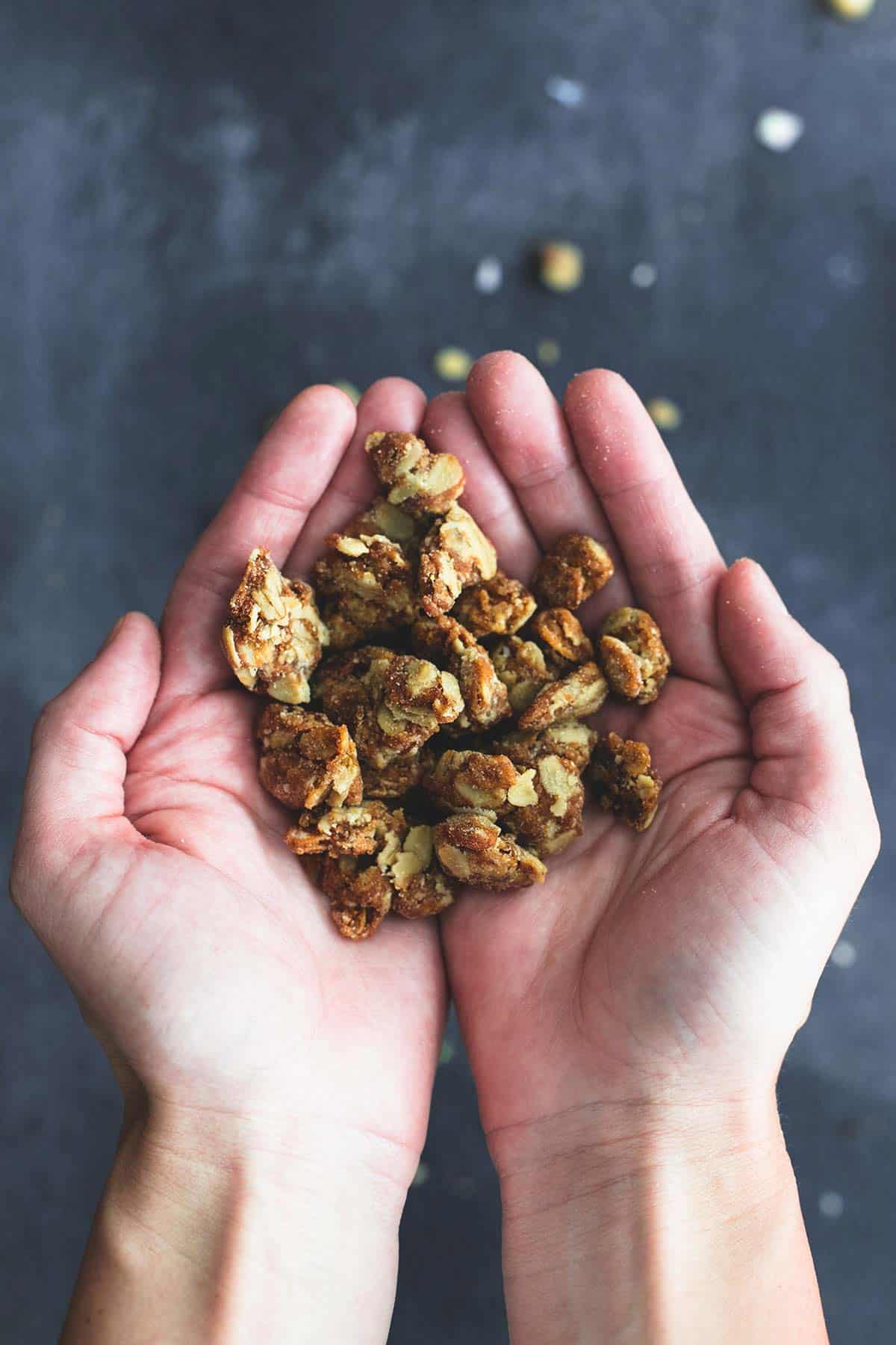 hands cupping granola clusters.