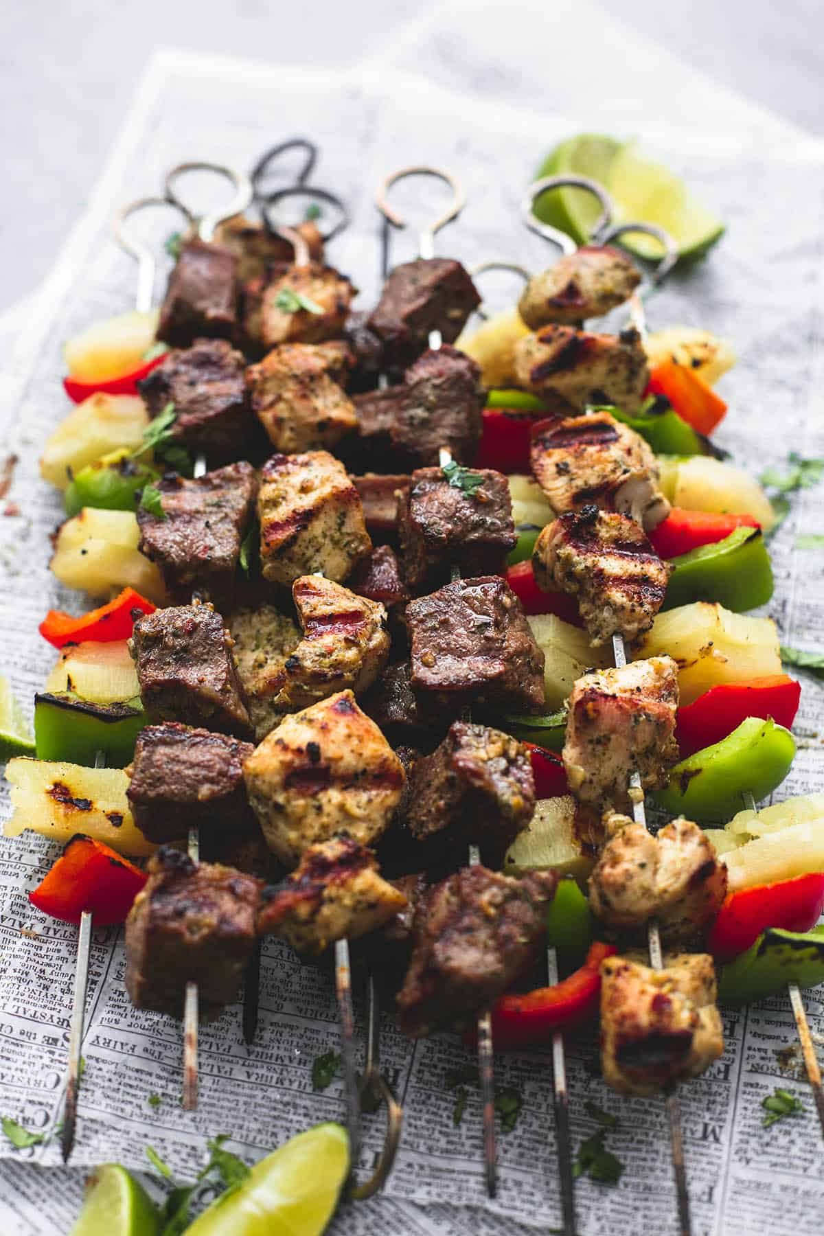 Brazilian steak & chicken kabobs with lime slices on the side.