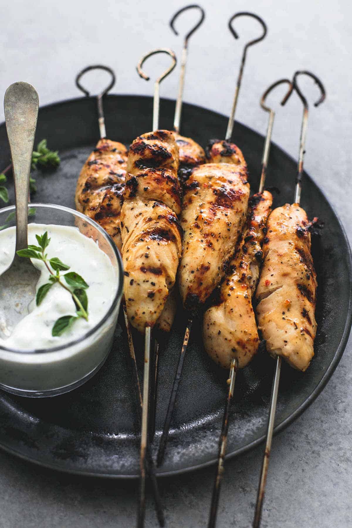 grilled chicken Souvlaki on skewers & Tzatziki sauce on a plate.