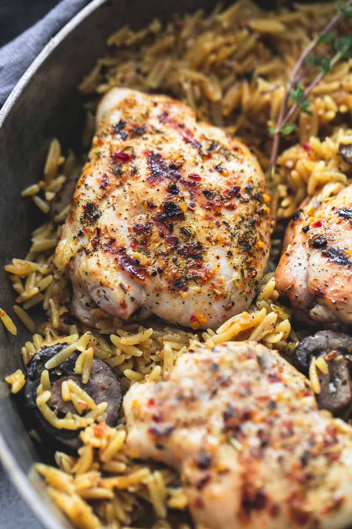 close up of mushroom herb chicken orzo in a pan.