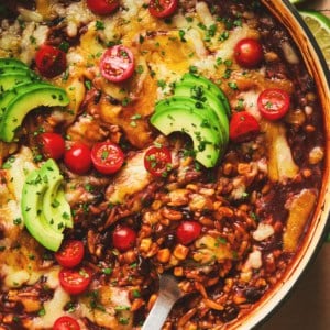 cheesy enchilada orzo pasta with serving spoon in cast iron pan