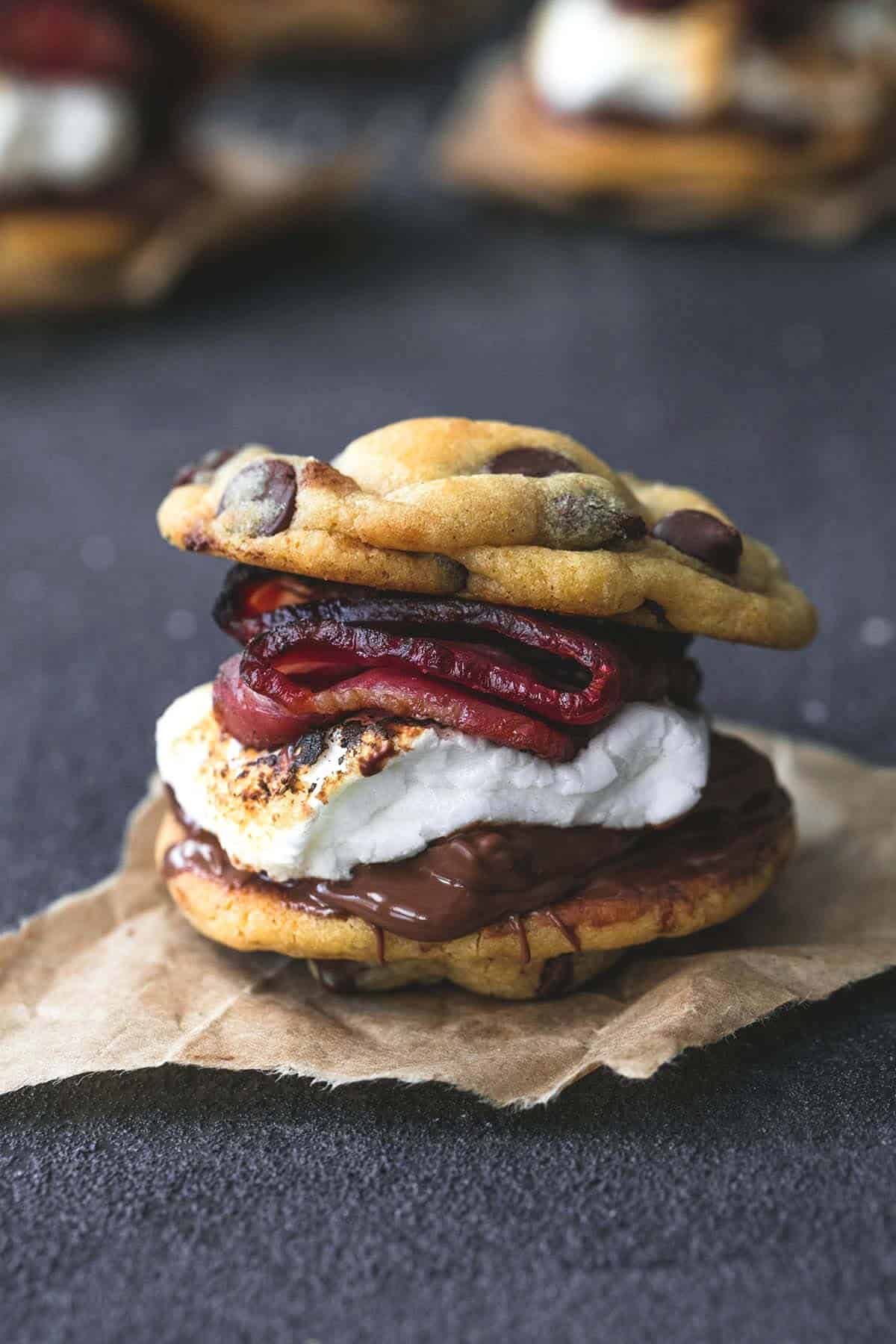 a grilled chocolate chip cookie bacon S'more with more S'mores in the background.