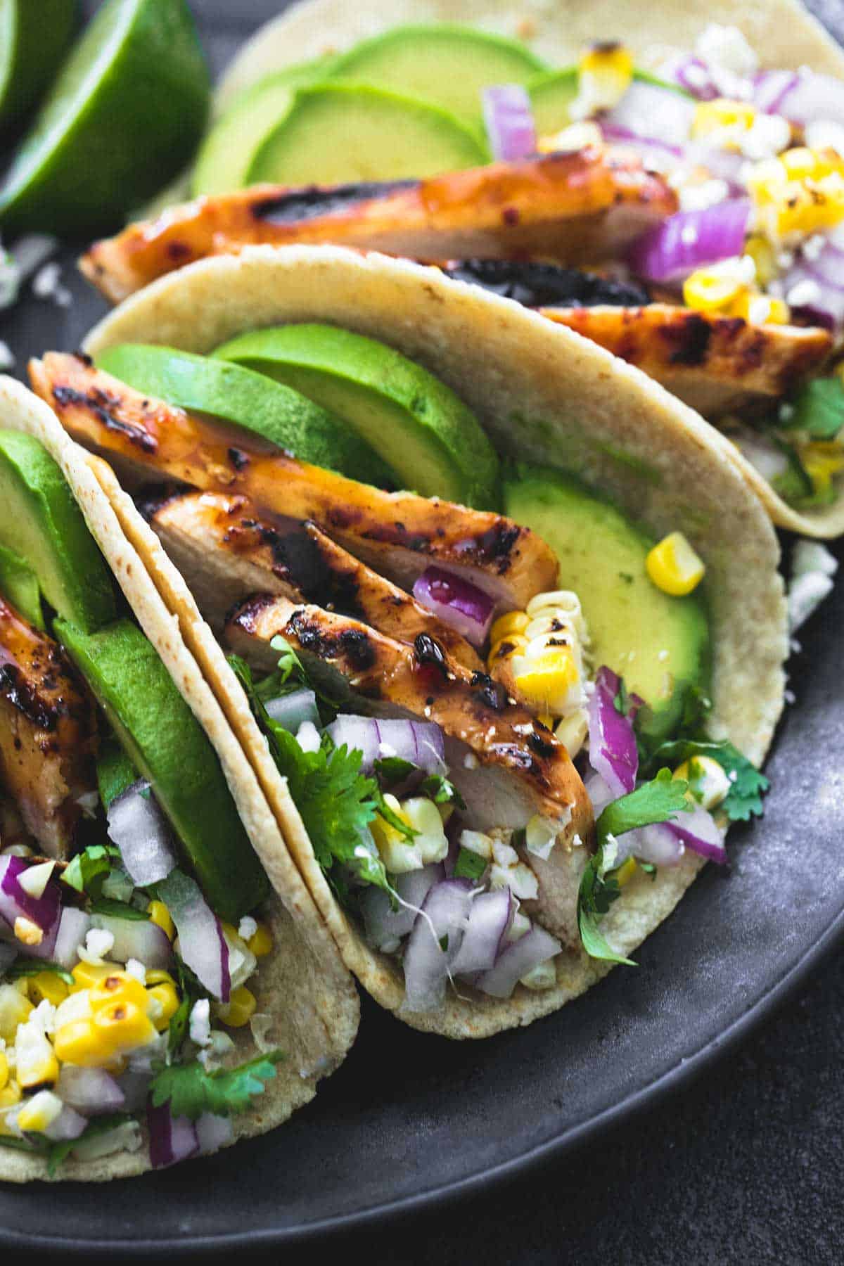close up of chicken tacos on a plate.
