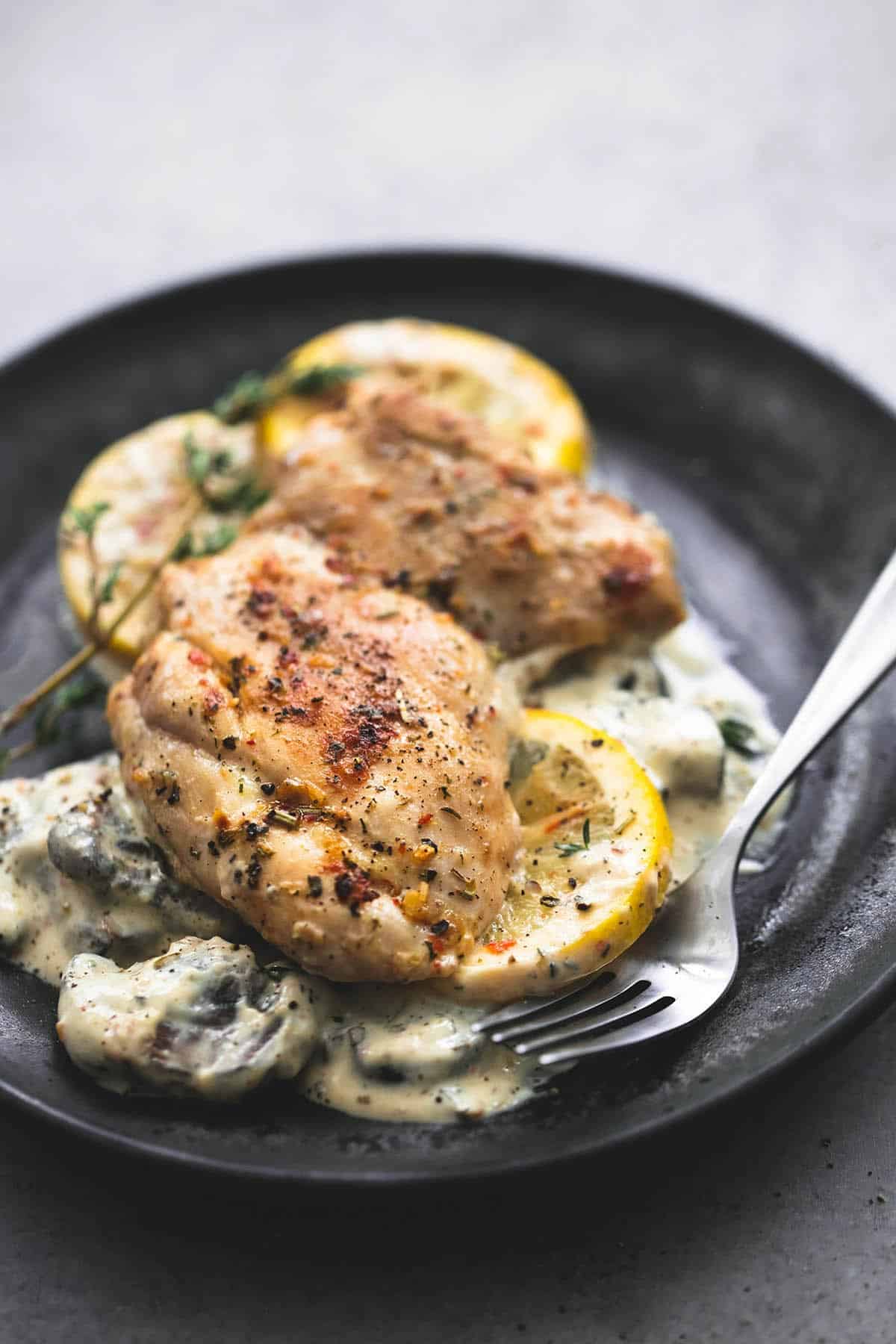 creamy lemon thyme chicken with a fork on a plate.