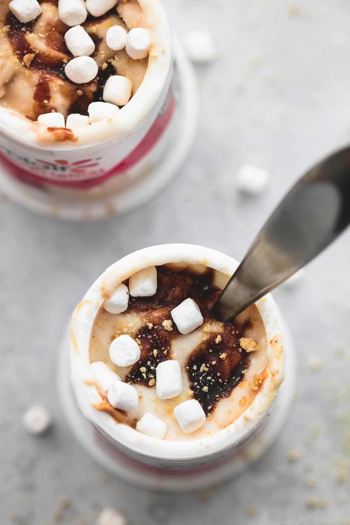 top view of peanut butter s'mores yogurt with a spoon in a Yoplait container with another yogurt container on the side.