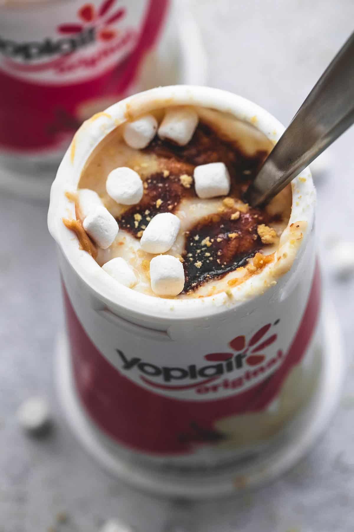 close up of peanut butter s'mores yogurt with a spoon in a Yoplait container.