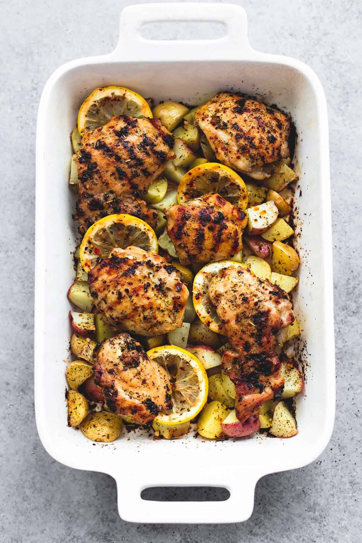 top view of baked lemon herb chicken & potatoes in a oven pan.