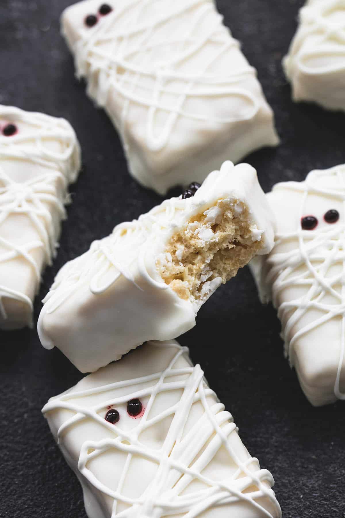 a rice krispie treat mummy leaning upward on more mummies with a bite missing.