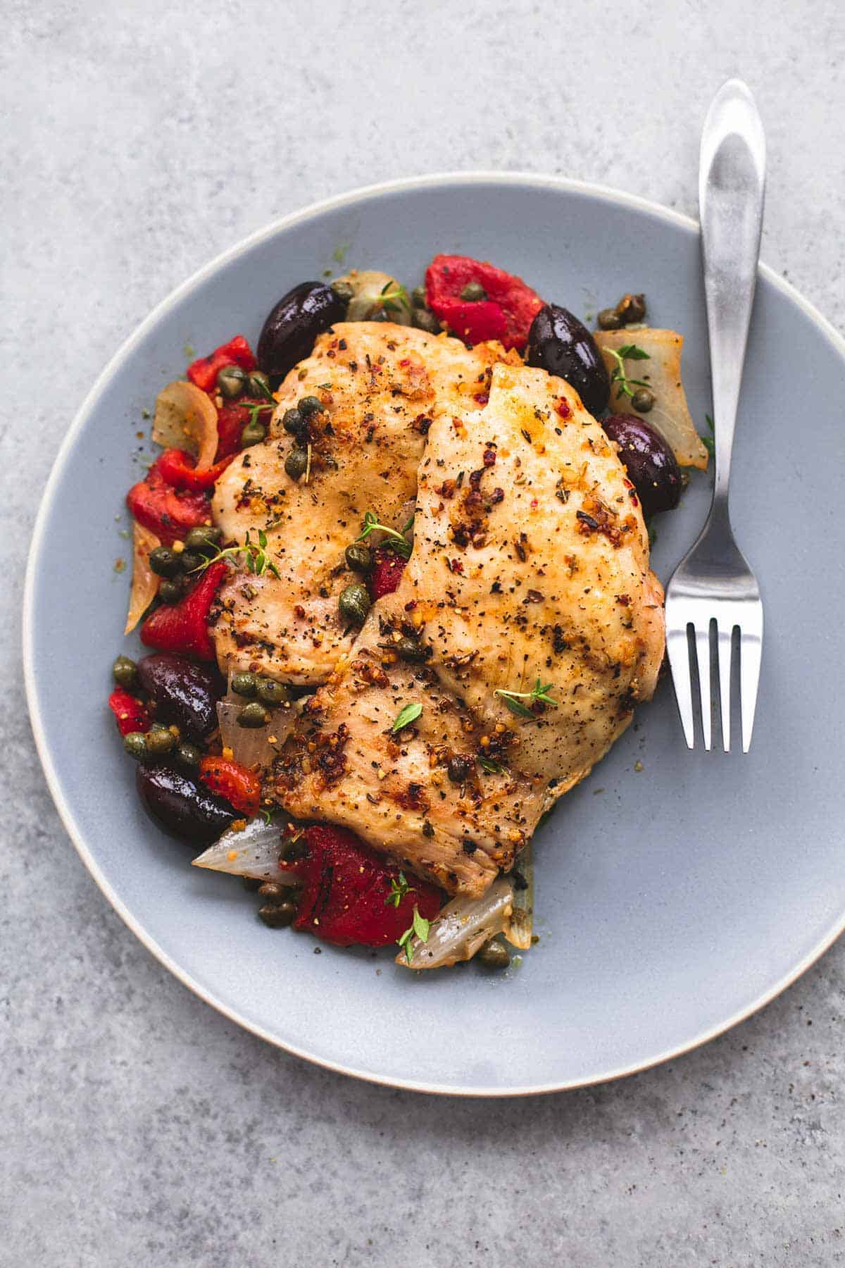 top view of slow cooker Mediterranean chicken with a fork on a plate.