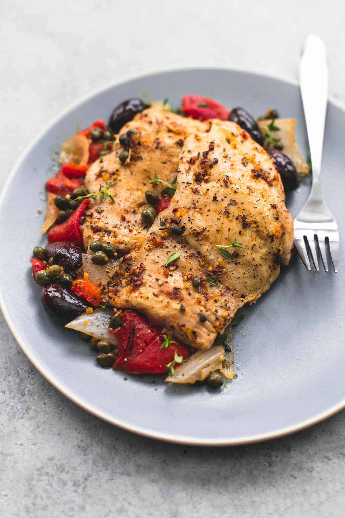 slow cooker Mediterranean chicken with a fork on a plate.