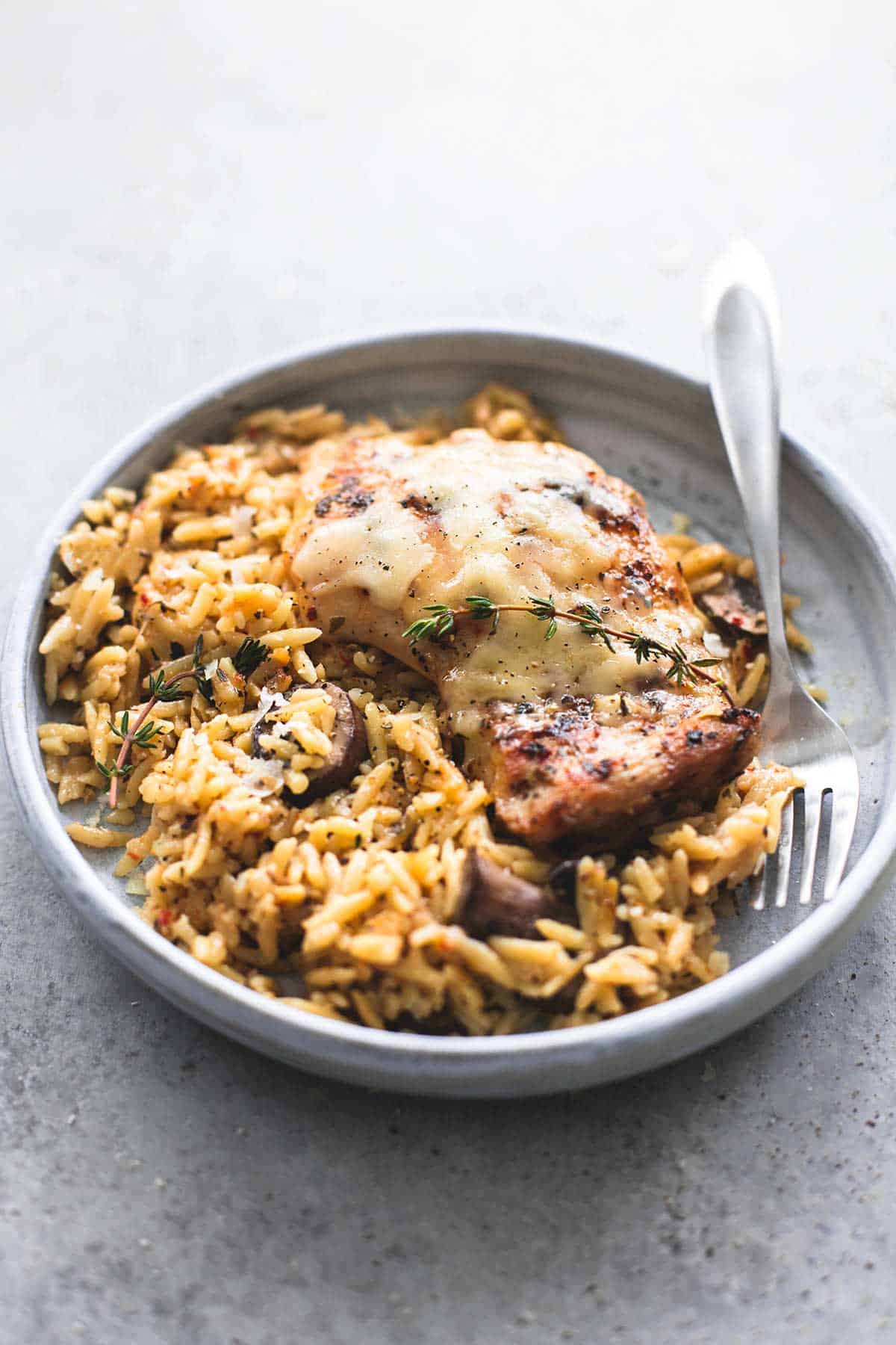 slow cooker parmesan herb chicken & orzo with a fork on a plate.