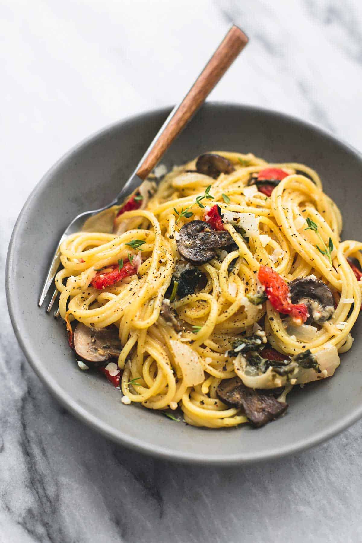 creamy Tuscan garlic spaghetti with a fork in a bowl.