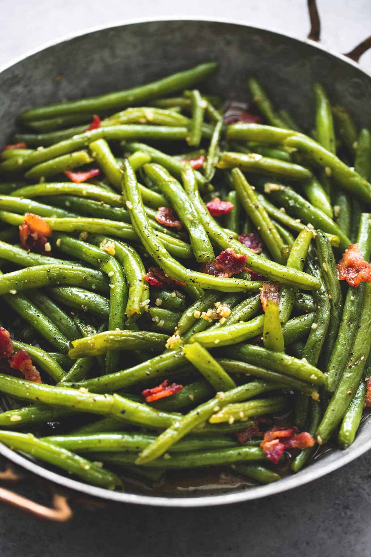close up of brown sugar green beans with bacon in a wok.