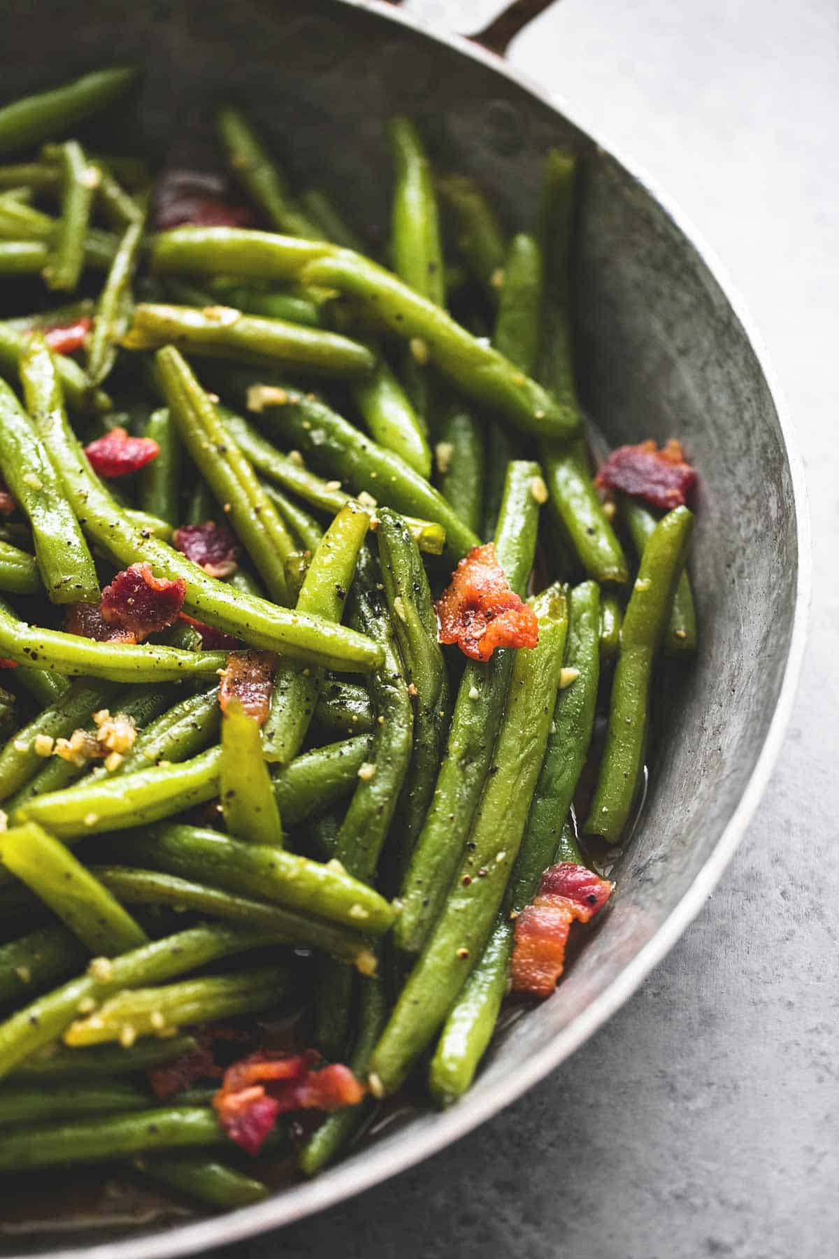 close up of brown sugar green beans with bacon in a wok.