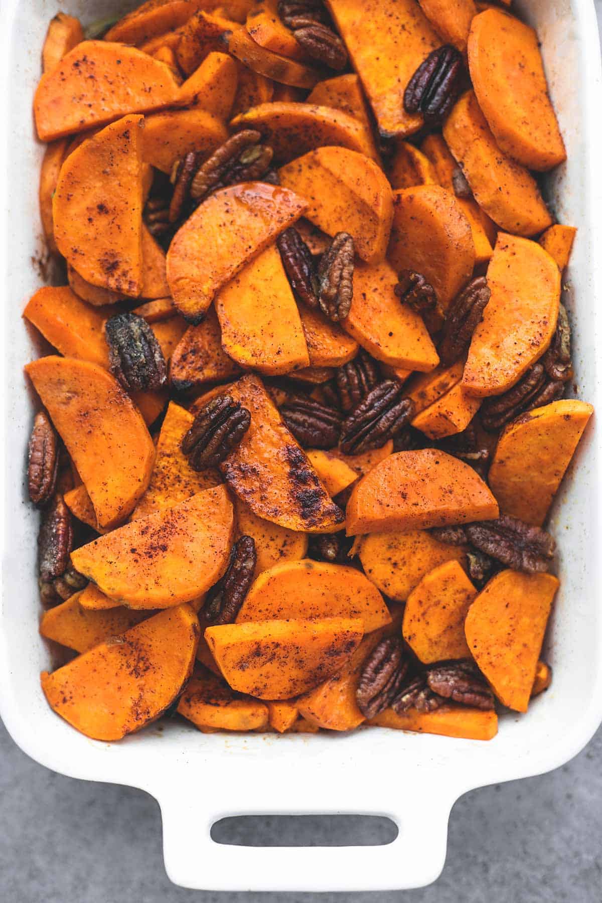 top view of baked Southern candied sweet potatoes with pecans in a baking dish.