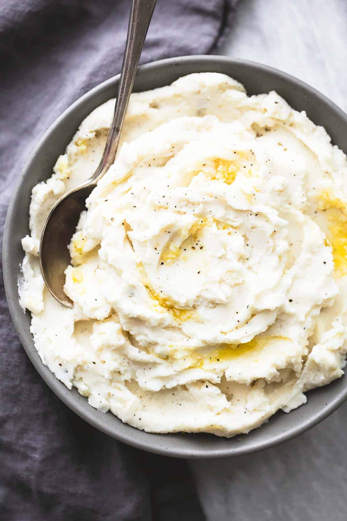 top view of garlic sour cream mashed potatoes with a spoon in a bowl.