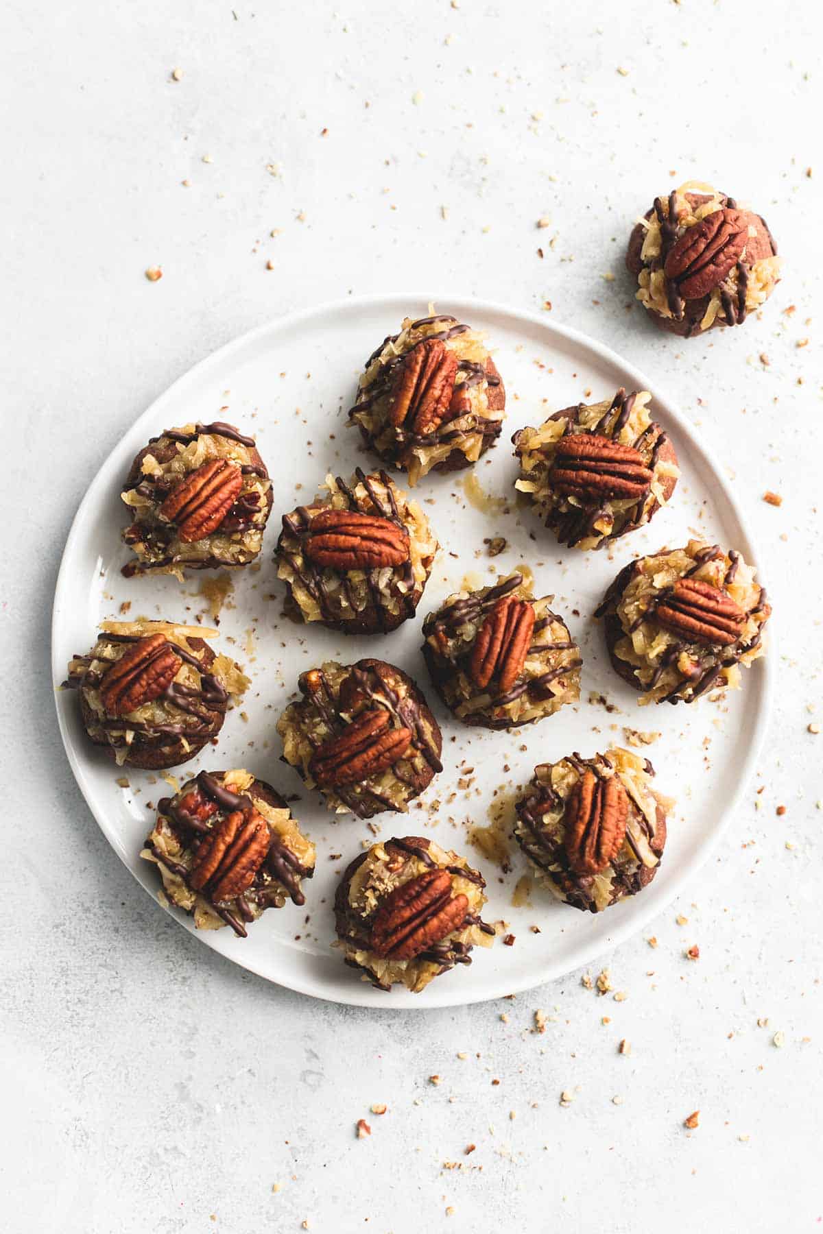 top view of German chocolate cookie balls on a plate with another cookie ball on the side.