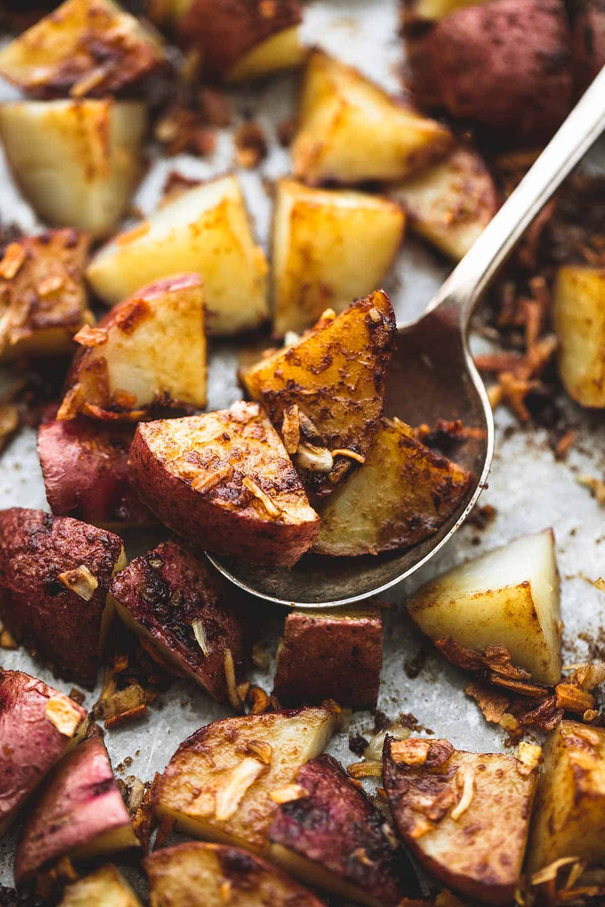 close up of oven roasted potatoes with a spoon.