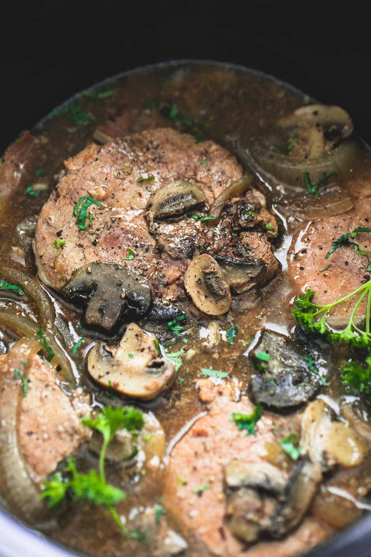 close up of slow cooker swiss steak in a slow cooker.