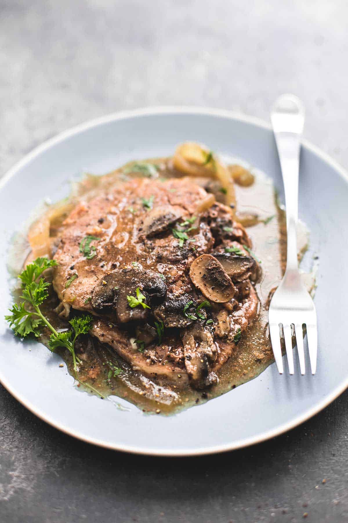 slow cooker swiss steak with a fork on a plate.