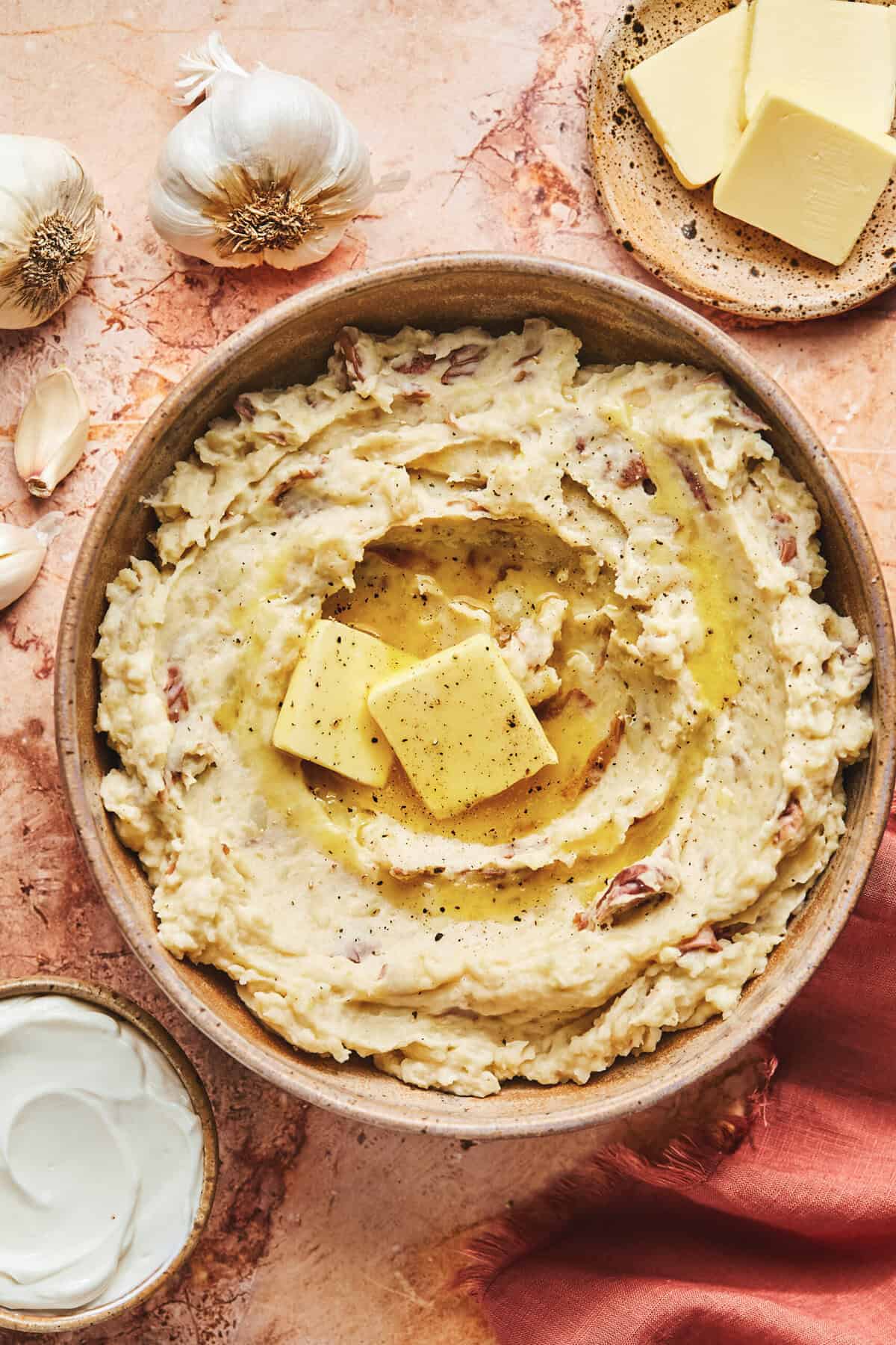 Overhead of garlic sour cream mashed potatoes in a ceramic bowl.