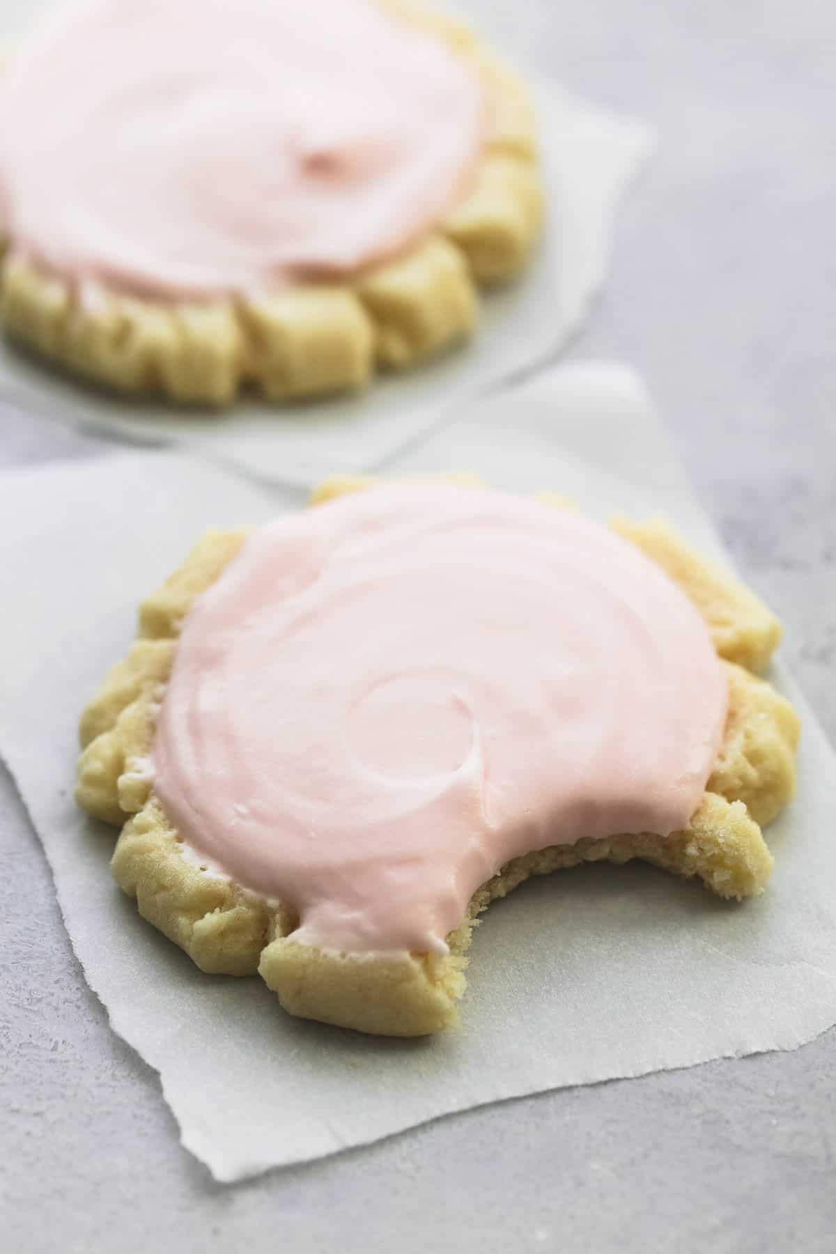 a copycat Swig sugar cookie with a bite missing with another cookie in the background.