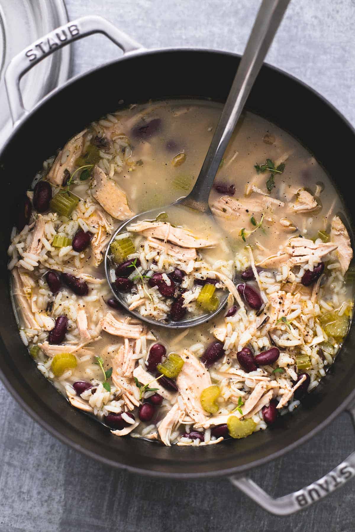 top view of healthy turkey wild rice soup with a serving spoon in a pan.