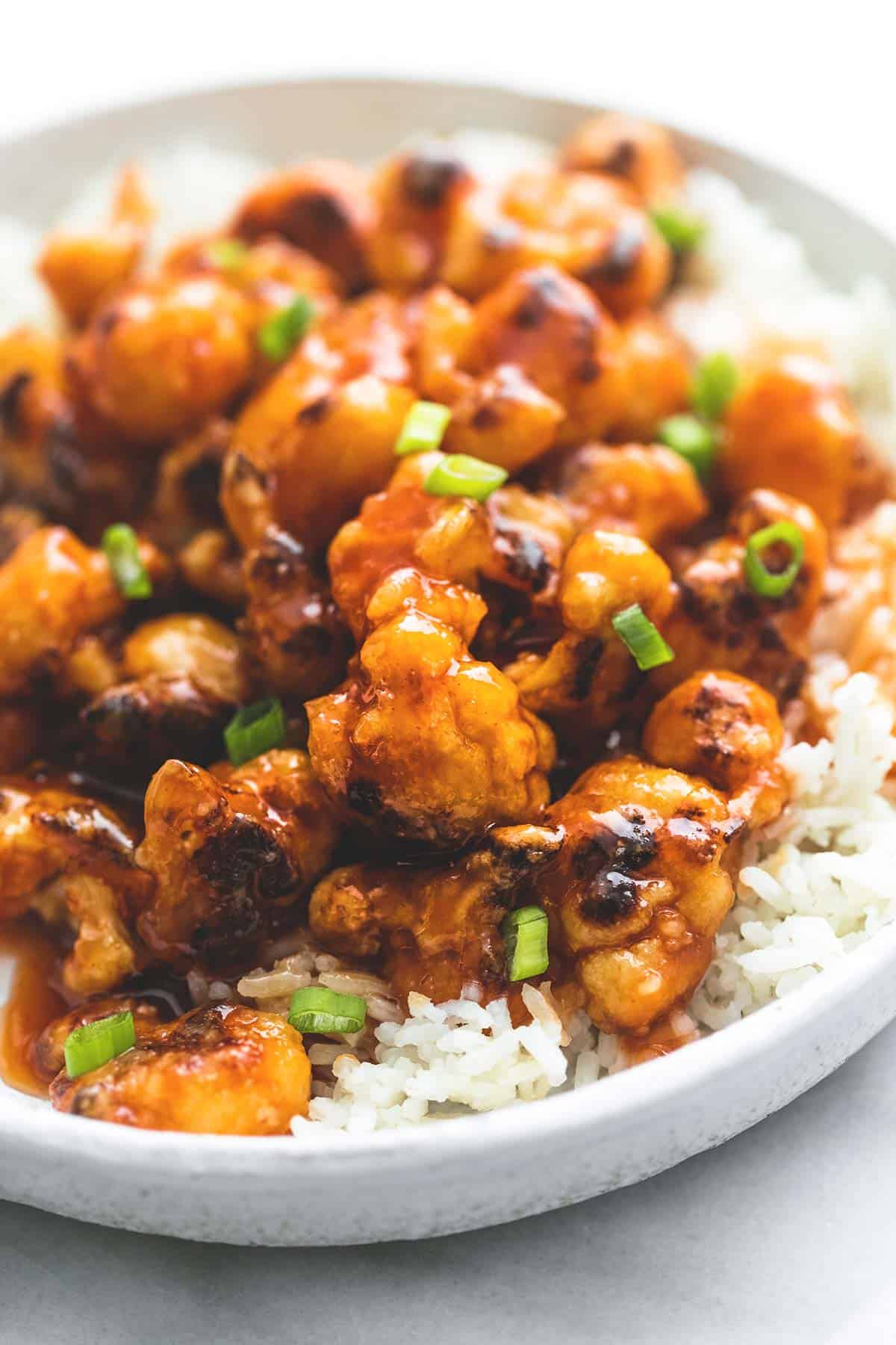 close up of baked sweet & sour cauliflower on rice on a plate.