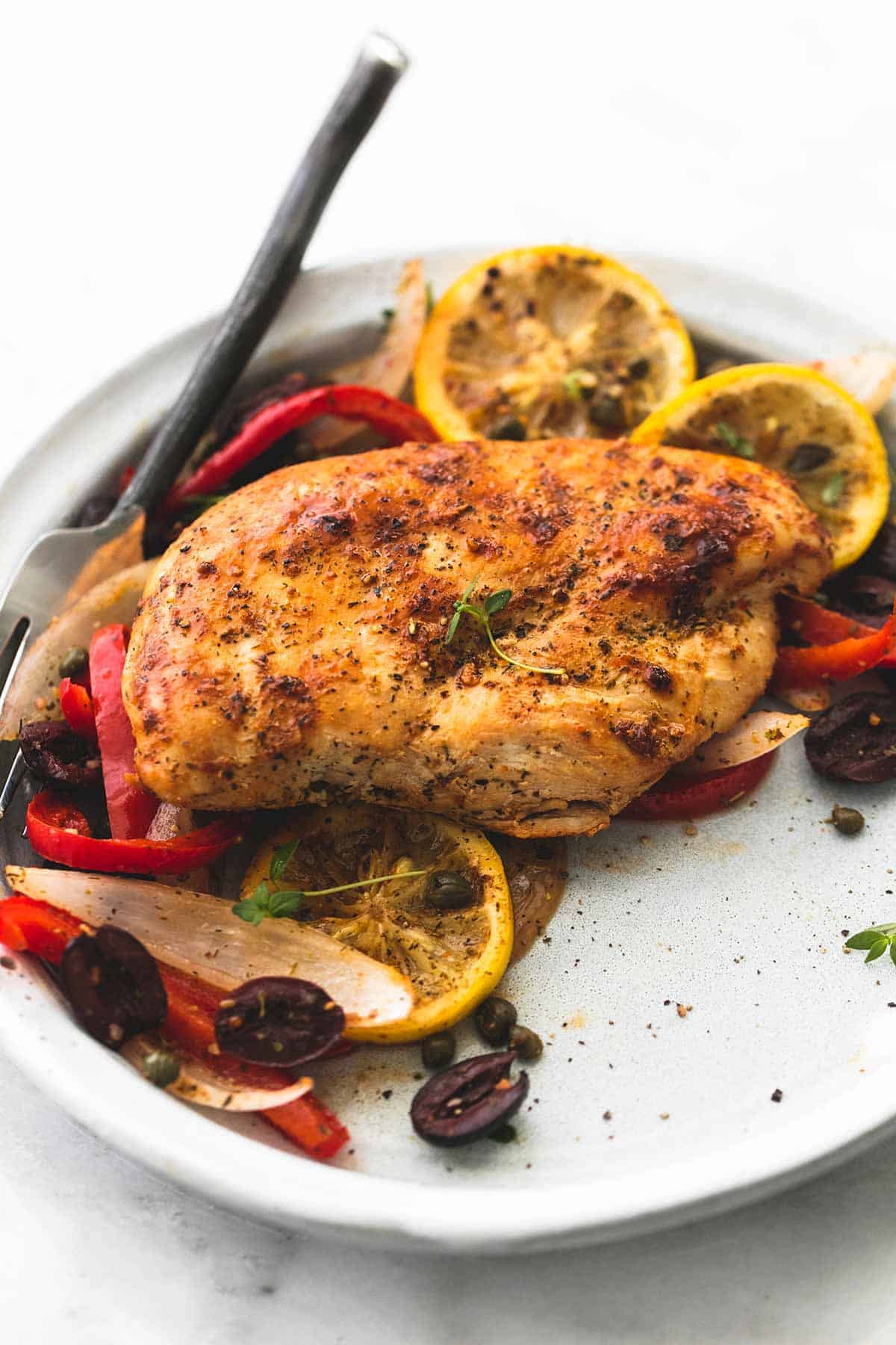 baked Greek chicken sheet pan dinner with a fork on a plate.