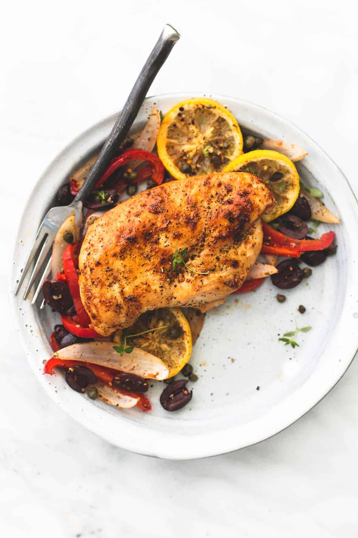 top view of baked Greek chicken sheet pan dinner with a fork on a plate.