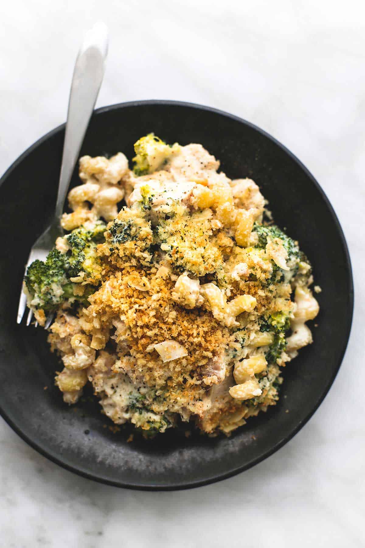 top view of baked chicken broccoli alfredo with a fork on a plate.