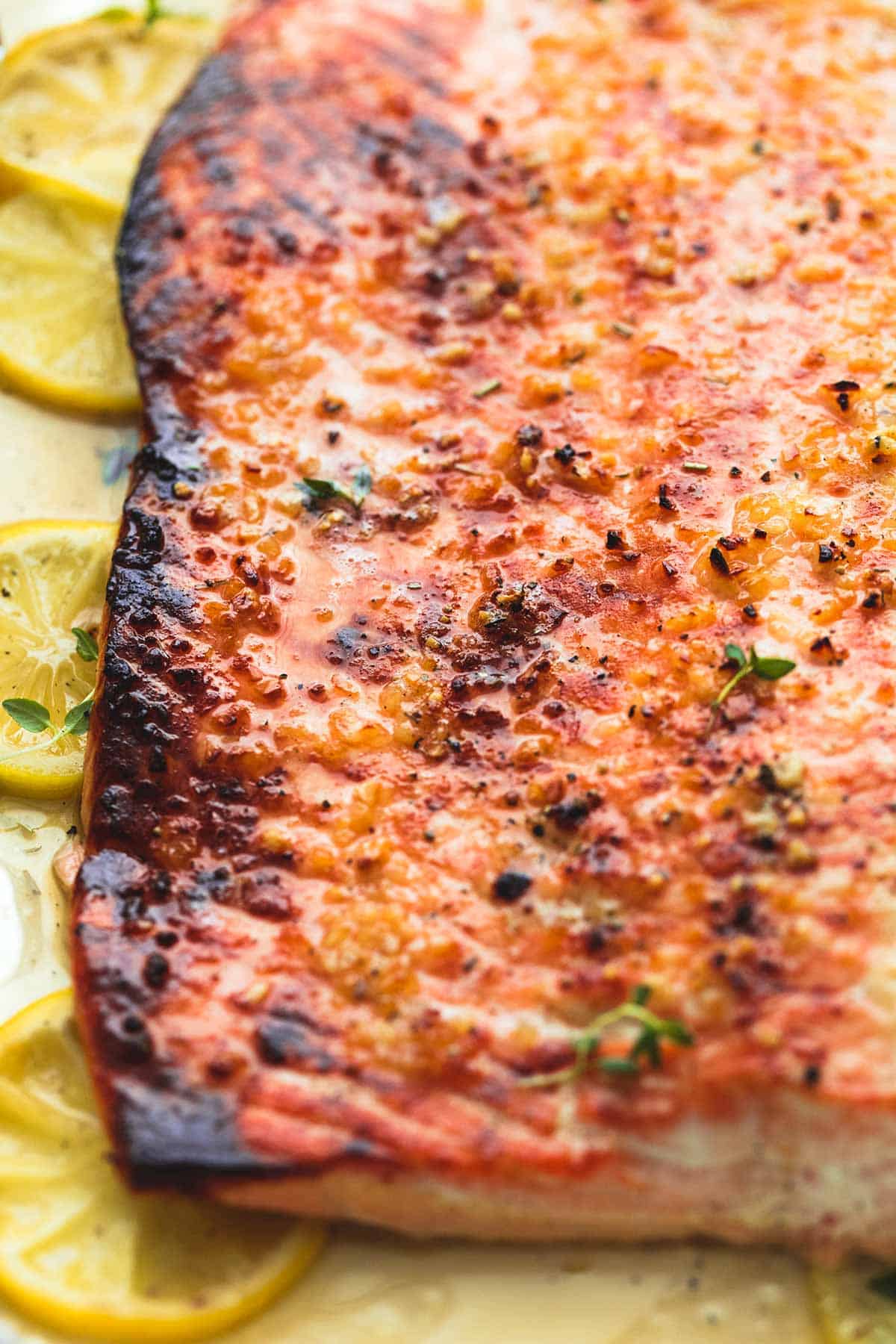 close up of baked honey lemon garlic salmon on top of lemon wheels.