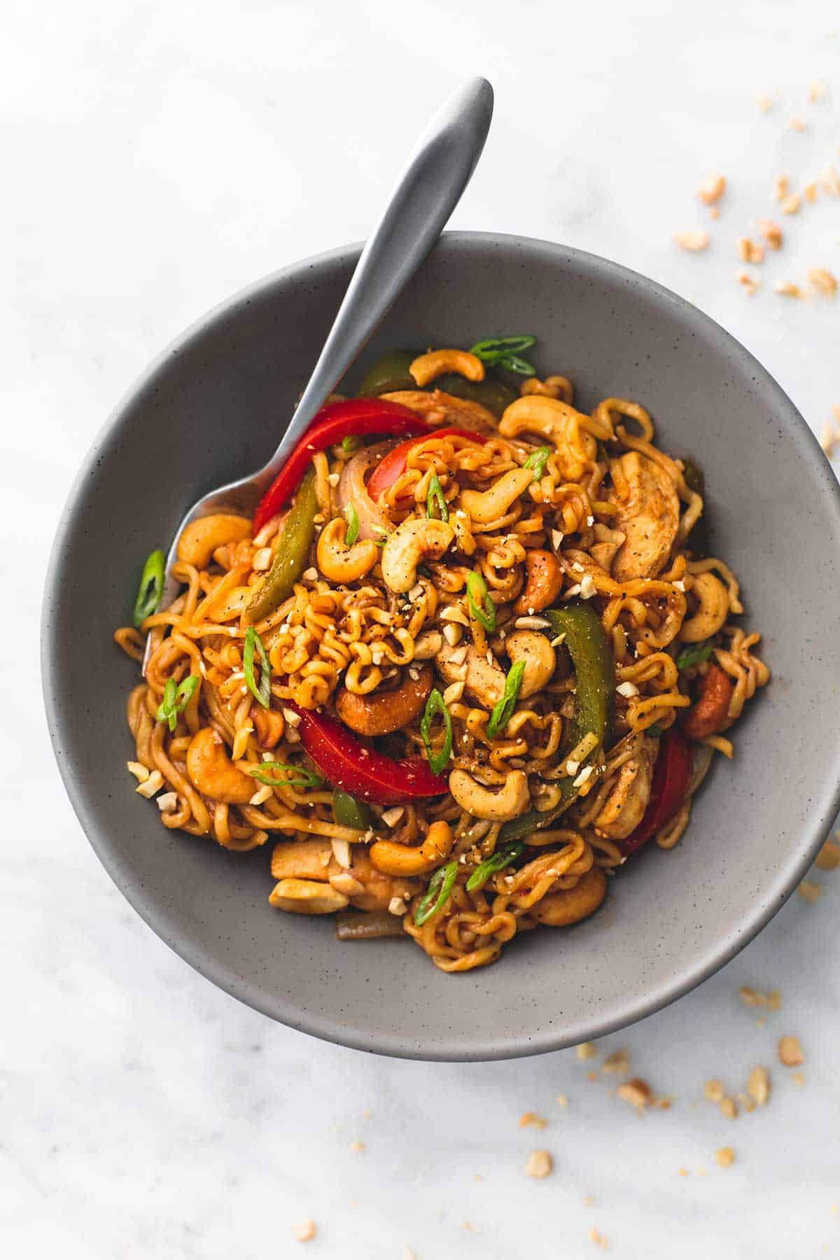 top view of cashew chicken ramen with a fork in a bowl.