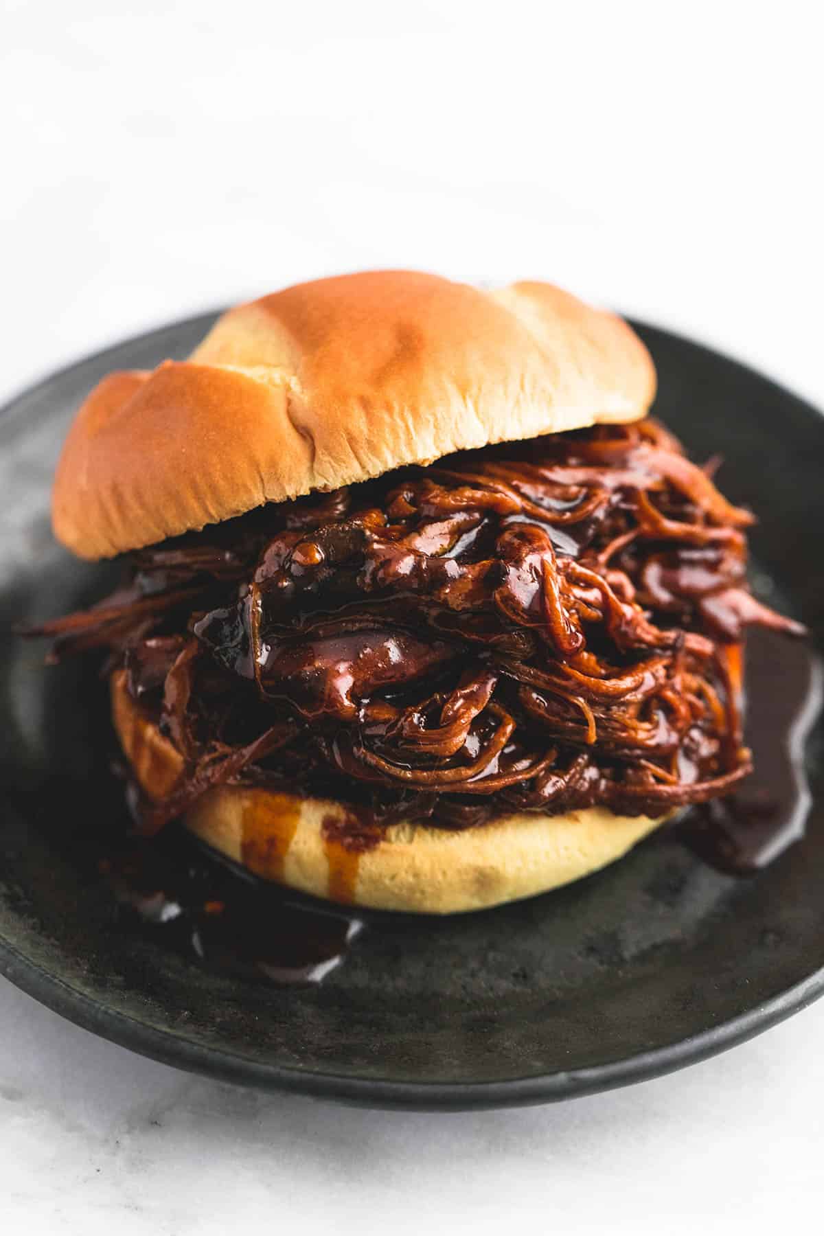 a slow cooker honey bbq beef brisket sandwich on a plate.