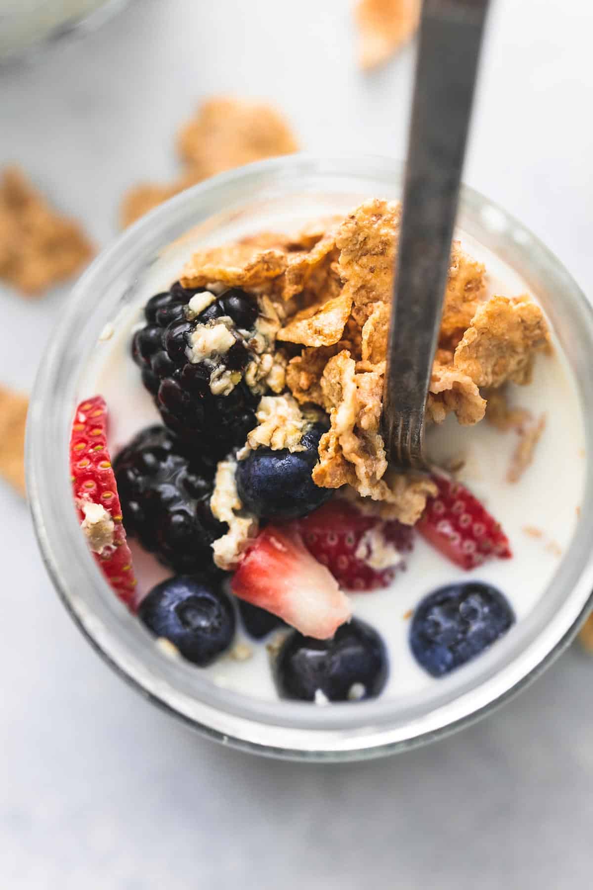 top view of berry crunch overnight oats with a spoon in a jar.