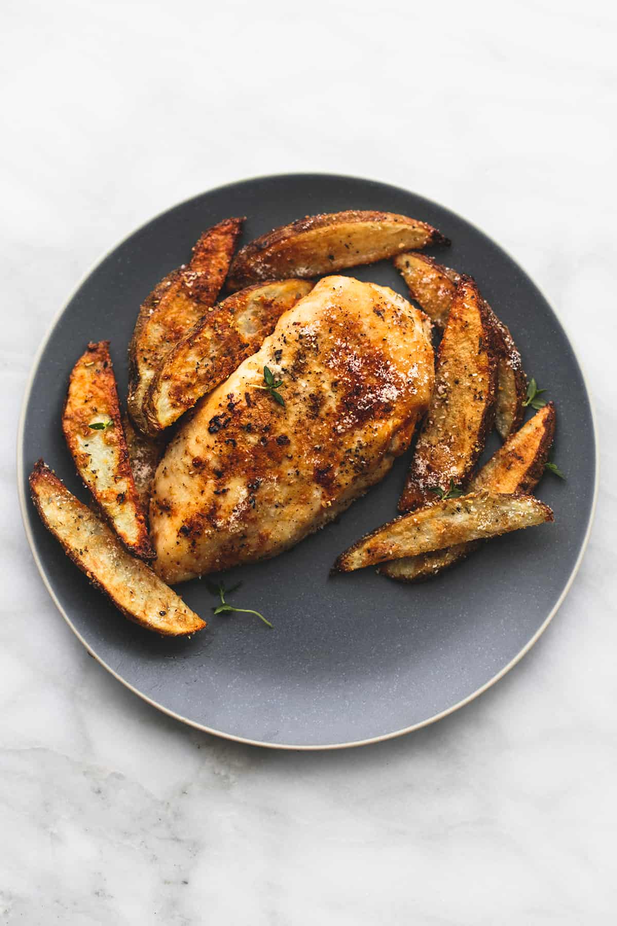 top view of garlic parmesan chicken & potatoes on a plate.