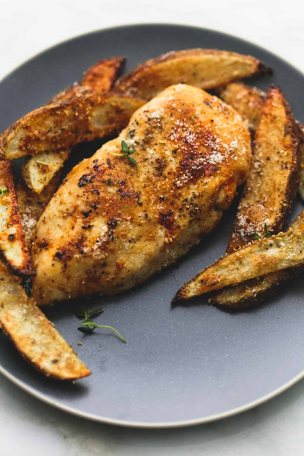 garlic parmesan chicken & potatoes on a plate.