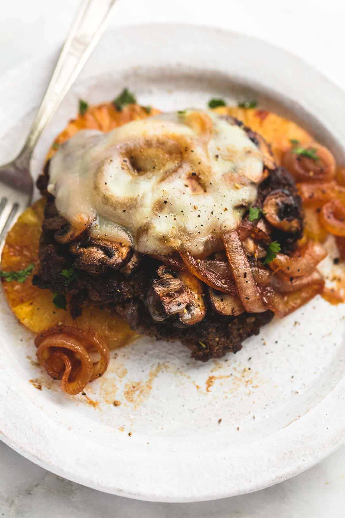 a Hawaiian hamburger steak with a fork on a plate.