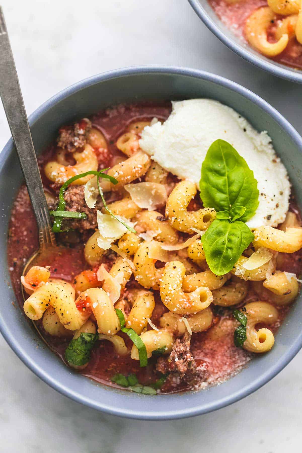 top view of slow cooker lasagna soup with a spoon in a bowl.