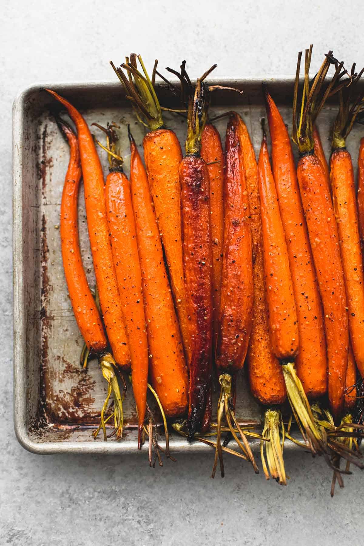 close up top view of honey brown sugar roasted carrots on a baking sheet.