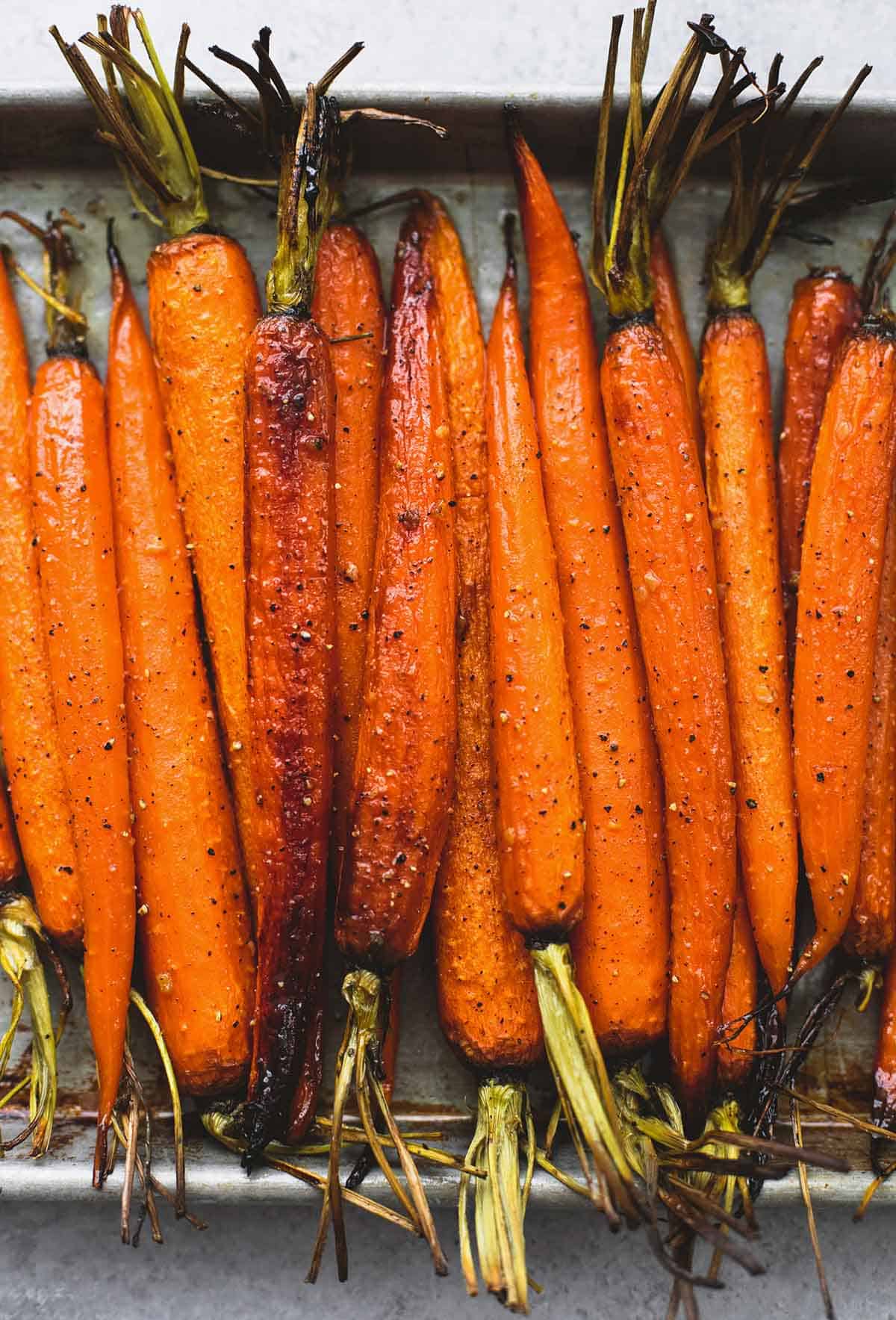 close up top view of honey brown sugar roasted carrots on a baking sheet.