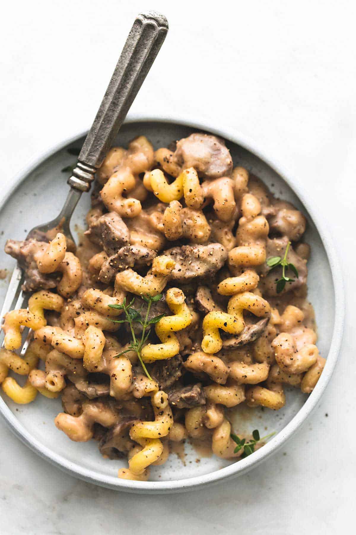 top view of slow cooker creamy beef stroganoff with a fork on a plate.